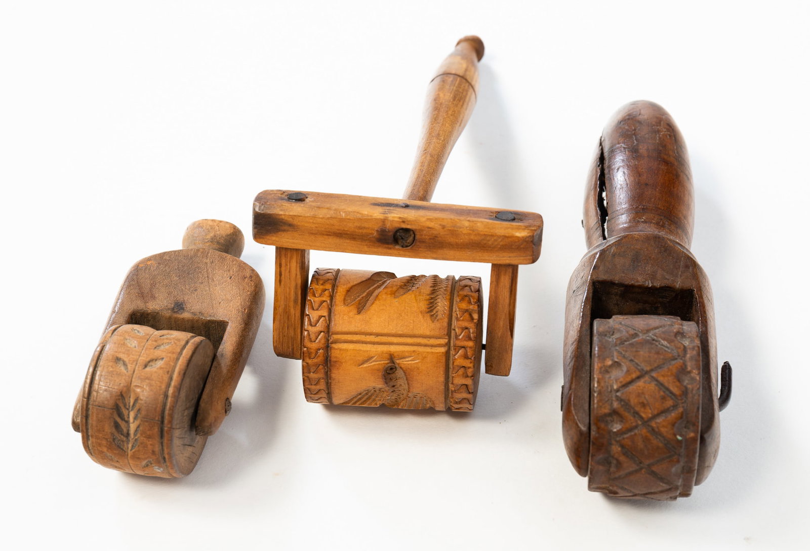 THREE SPRINGERLE WOODEN ROLLERS OR COOKIE MOLDS.: American or Continental, 19th Century. Three rollers with handles each carved with designs, the first an early example with a diamond and dot pattern, the second with a leaf design, and the third with