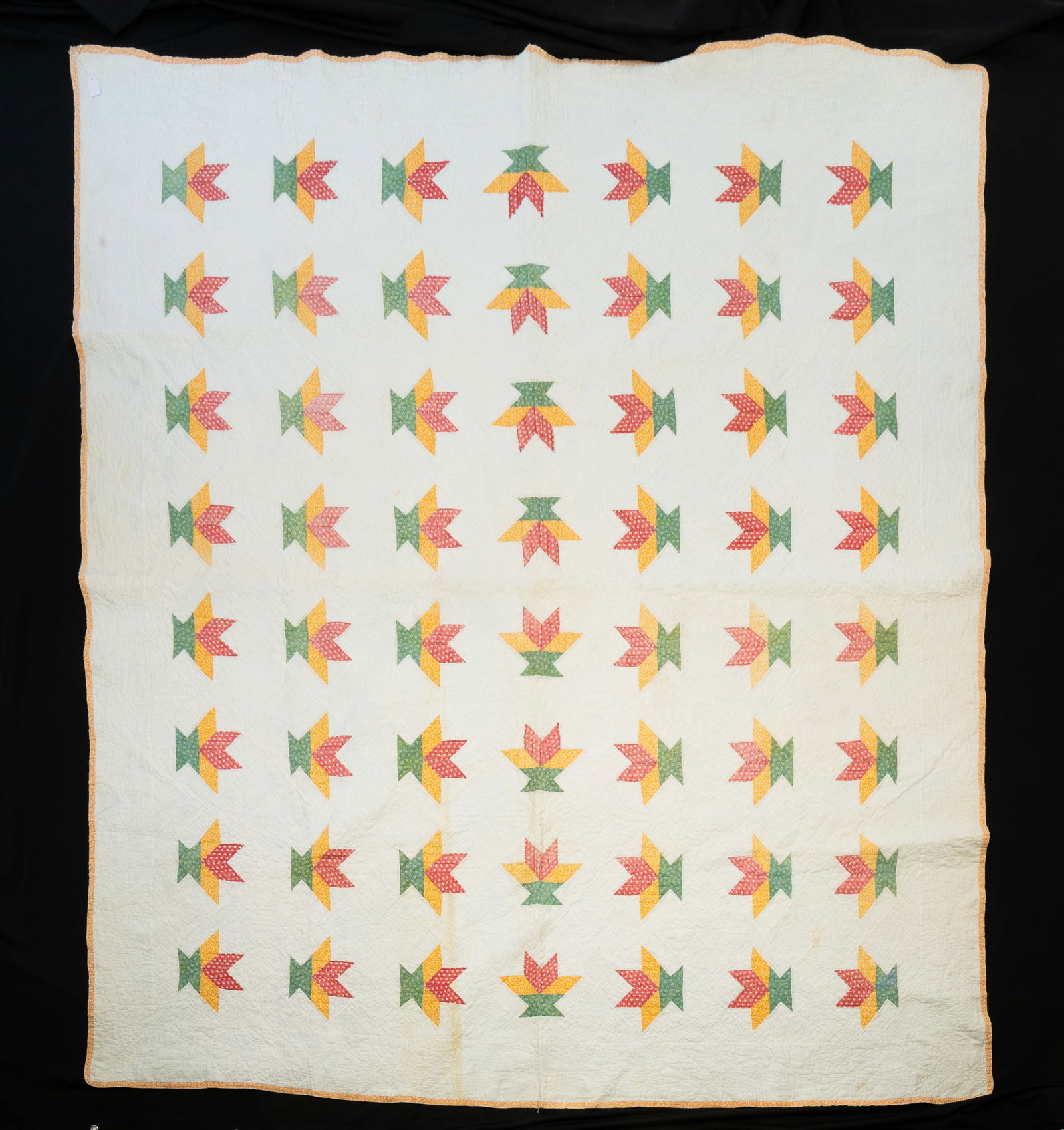 AMERICAN PIECEWORK BASKET VARIANT QUILT.: American, Early 20th Century. Cotton. White field with baskets comprised from yellow, green, and red patterned baskets and yellow trim. 84"w. 74"l.