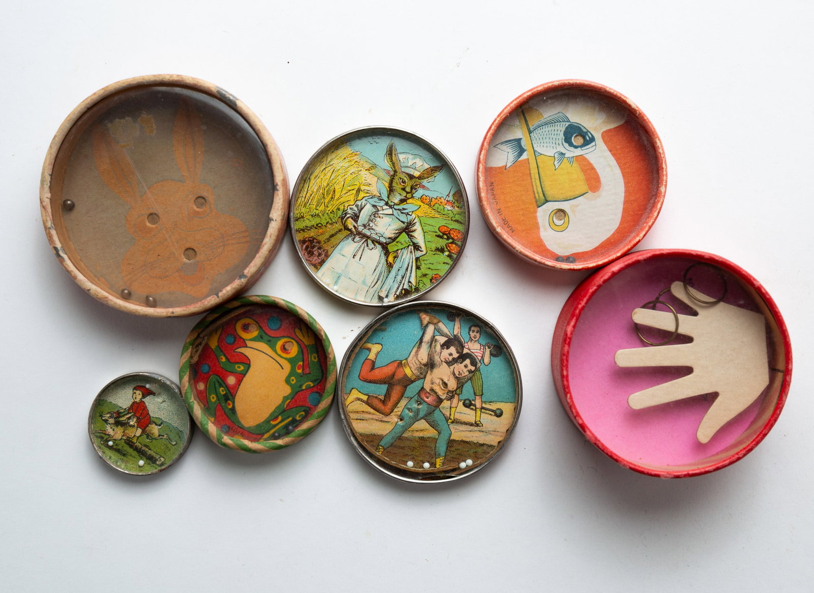 COLLECTION OF SEVEN DEXTERITY OR PATIENCE PUZZLES.: American, European, and Japanese, 20th Century. Paper and metal. Depicting assorted whimsical illustrations, one is double-sided. From 1.25"d. to 3"d.