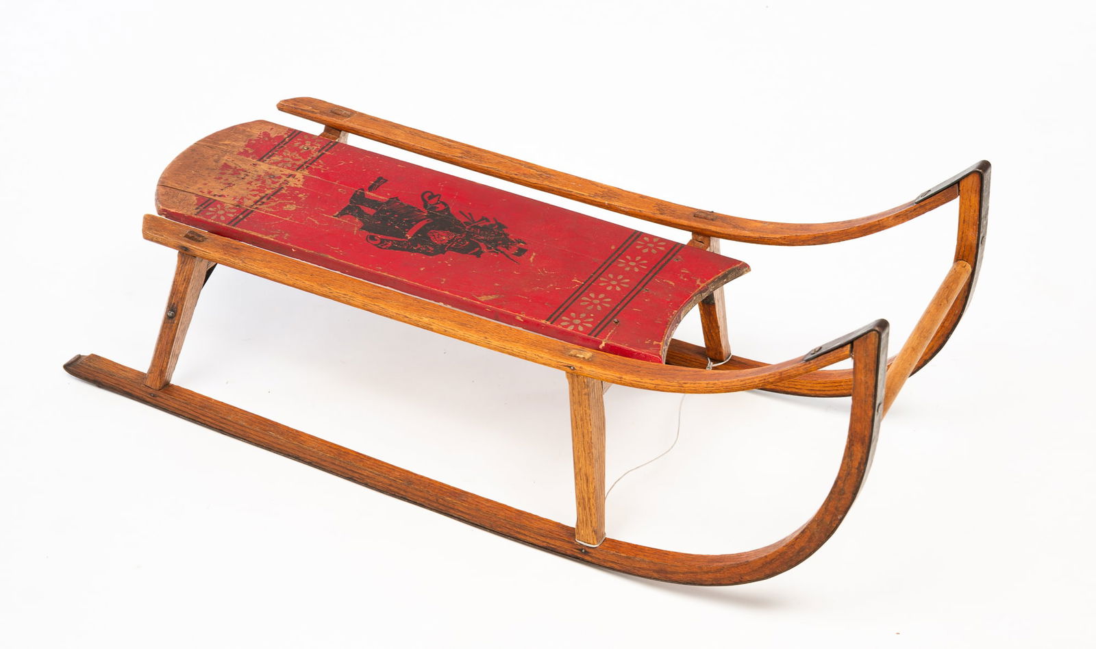 PARIS MFG. CO. (SOUTH PARIS, MAINE) PAINT-DECORATED WOOD AND STEEL SLED WITH SANTA CLAUS MOTIF.: Paris Mfg. Co. (South Paris, Maine), Early 20th Century. Curved steel over oak runners and supports, shaped pine seat with dark red paint, stenciled Stanta to center. Stamped Paris Mfg. Co. label to b