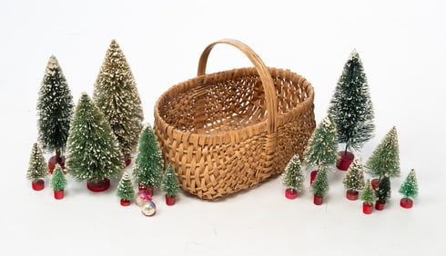 GROUP OF BOTTLE BRUSH CHRISTMAS TREES IN SPLINT BASKET.