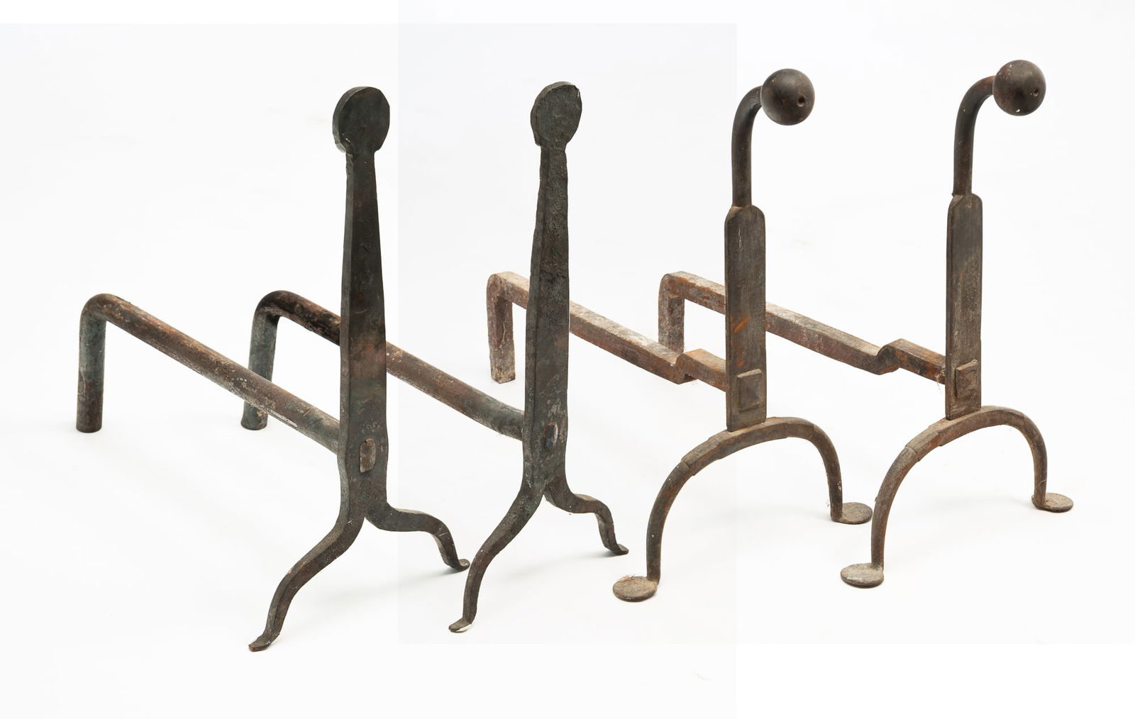 TWO PAIRS OF AMERICAN WROUGHT IRON ANDIRONS.: American, 20th Century. In the 18th Century style. Wrought iron. One pair of knife blade andirons with circular tops, 13.75"h. 11.75"d. And the second pair are forged iron with arched tops with balls,