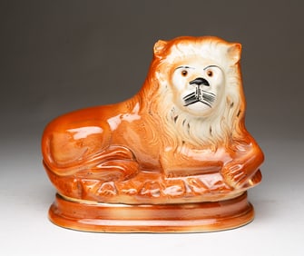 LARGE RECUMBENT STAFFORDSHIRE LION FIGURINE.