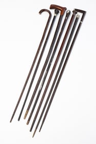 COLLECTION OF STACKED LEATHER CANES AND WALKING STICKS.