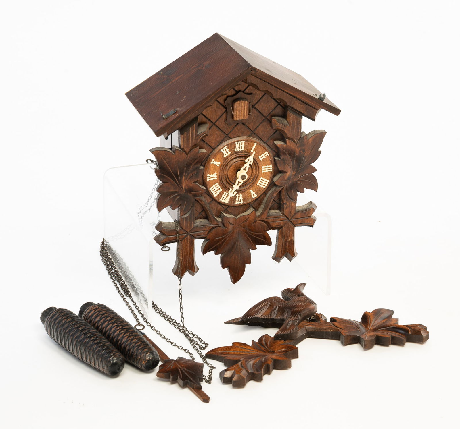 GERMAN BLACK FOREST CUCKOO CLOCK.: Germany, 20th Century. Carved bird and foliage with pine cone weights. 149"h. 12''w. 5.5"d.