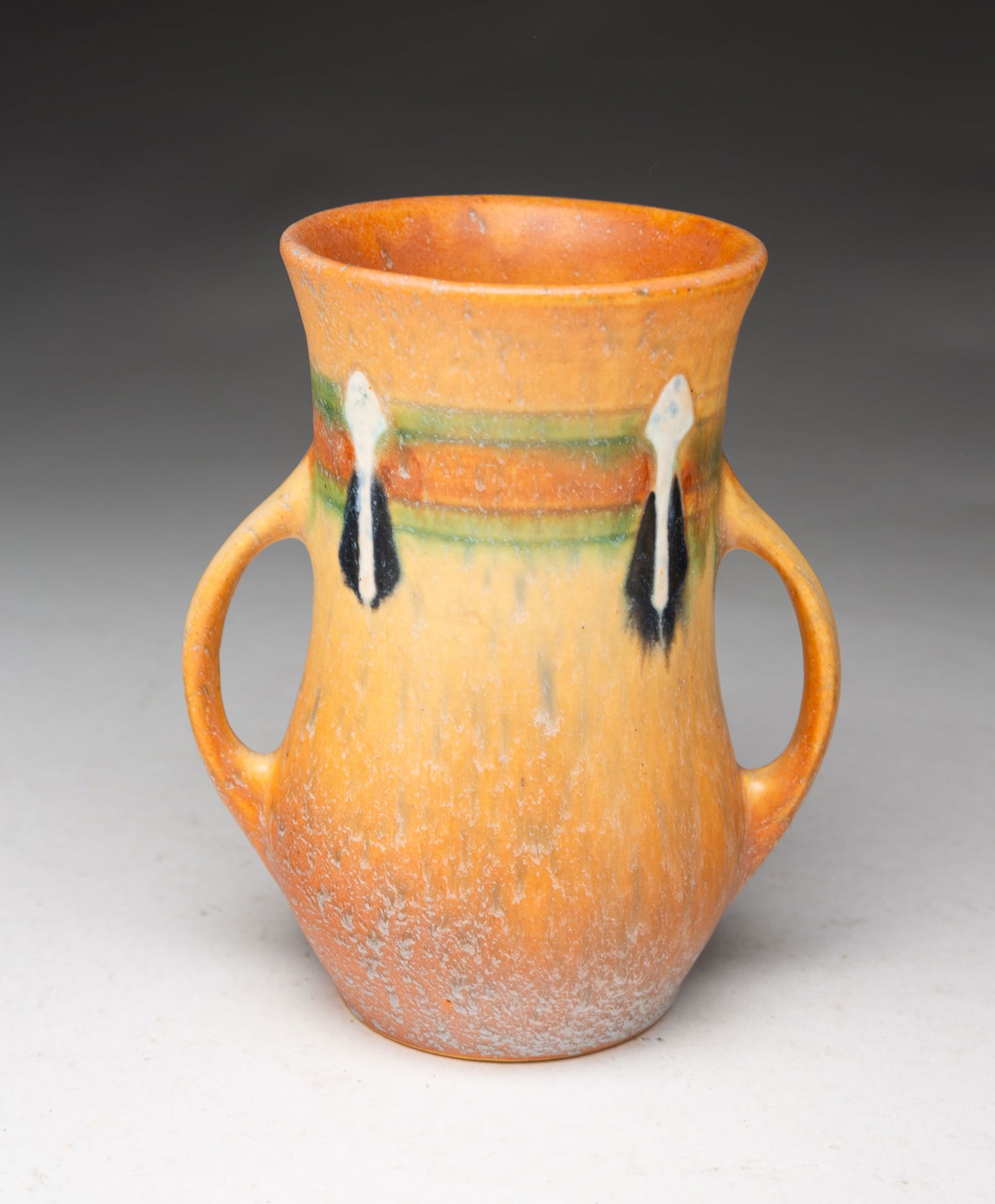 ROSEVILLE POTTERY CO. (ROSEVILLE, OHIO) "MONTICELLO" DOUBLE-HANDLED VASE.: Roseville Pottery Company (Roseville, Ohio), Early 20th Century. Cylindrical form with two strap handles with banded decoration and white and black drops. 5.25"h. 3.25"d.