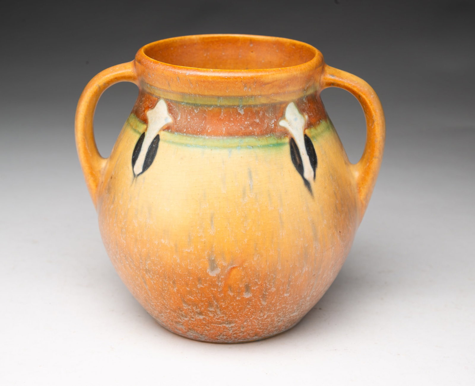 ROSEVILLE POTTERY CO. (ROSEVILLE, OHIO) "MONTICELLO" DOUBLE-HANDLED VASE.: Roseville Pottery Company (Roseville, Ohio), Early 20th Century. Bulbous bottom with two strap handles with banded decoration with white drop finials. 5.25"h. 5"d.