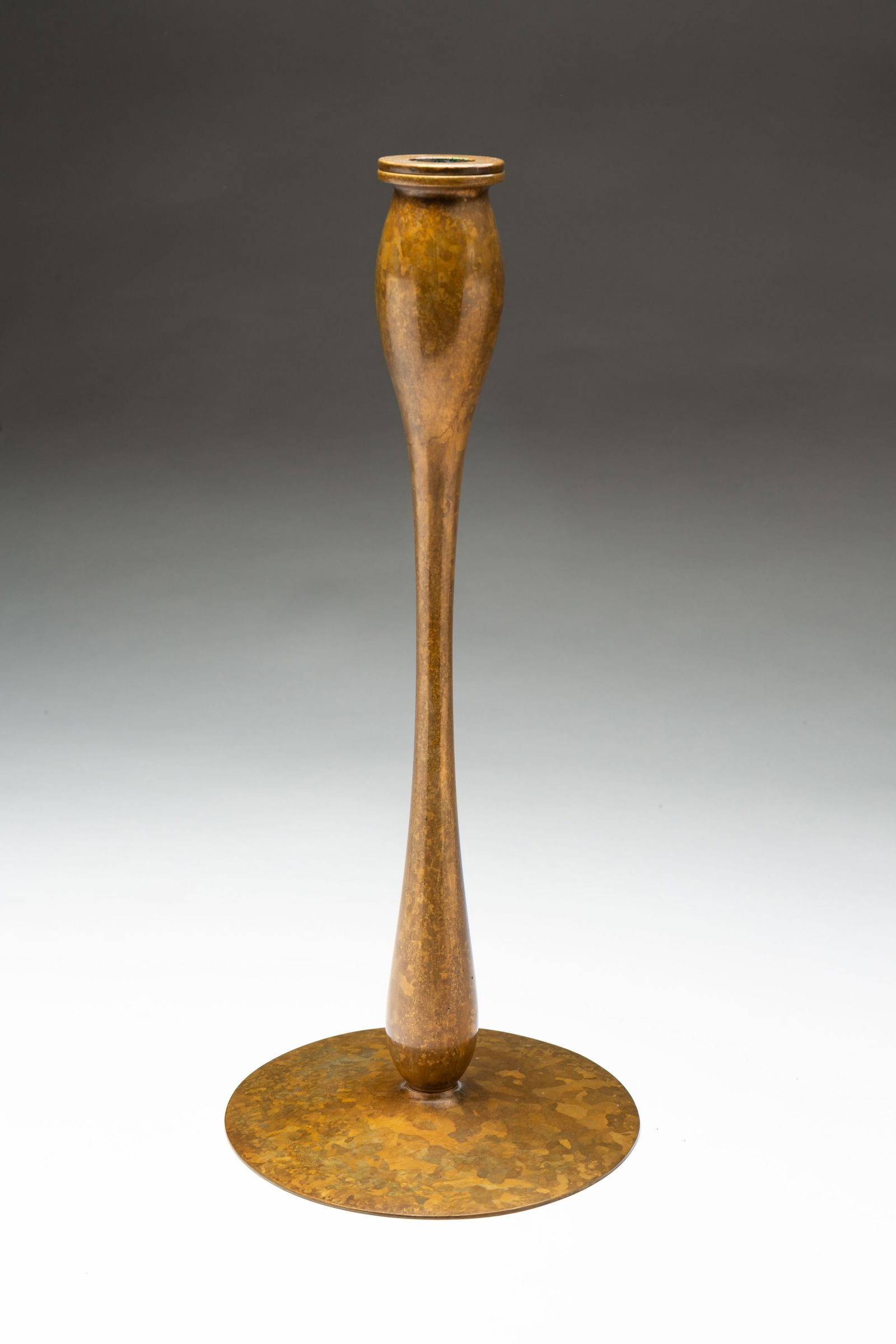 UNITED CRAFTS (AMERICAN) ARTS AND CRAFTS PATINATED BRONZE CANDLESTICK.: United Crafts (American), Early 20th Century. Bronze. Having a removable candle cup, in a mottled finish, signed on bottom of bobeche and on underside. 13.25"h. 6"d.