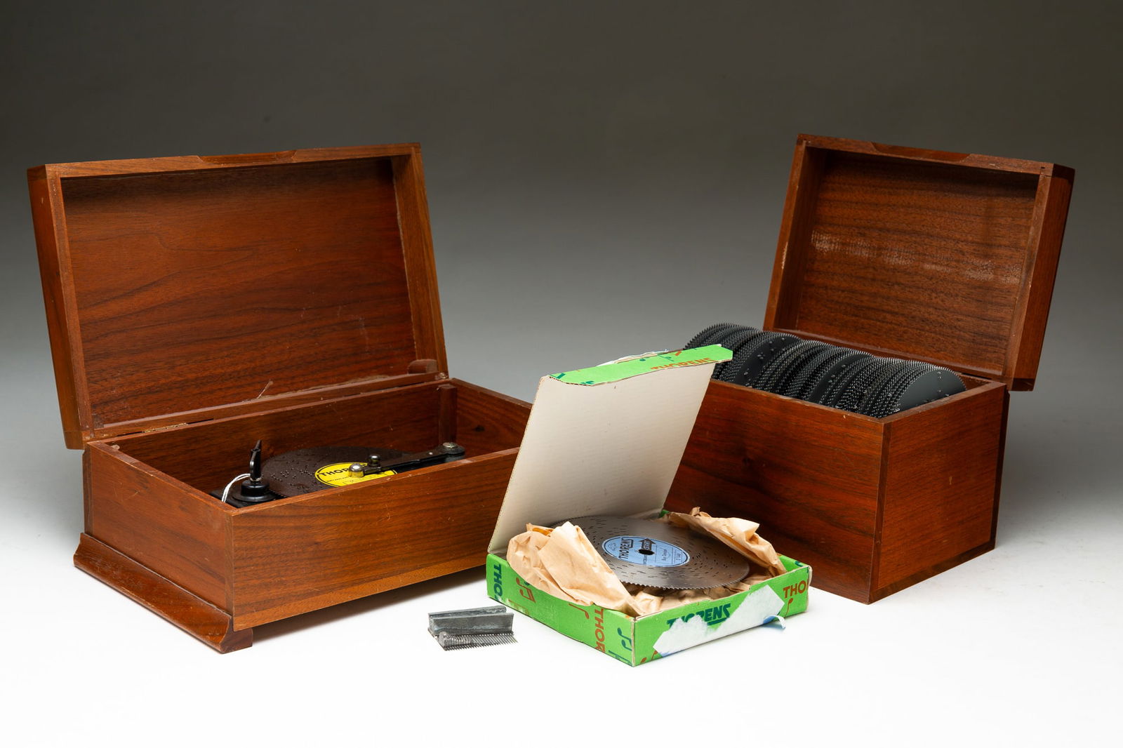 SWISS THOREN MUSIC BOX AND DISKS.: Switzerland, 20th Century. Walnut box with thirty note 4.5" disk spring wind player. 4"h. 10.75"w. 6.25"d. Comes with a mahogany box and approximately forty-nine 4.5" disks. 5.5"h. 7.25"w. 5.25"d.