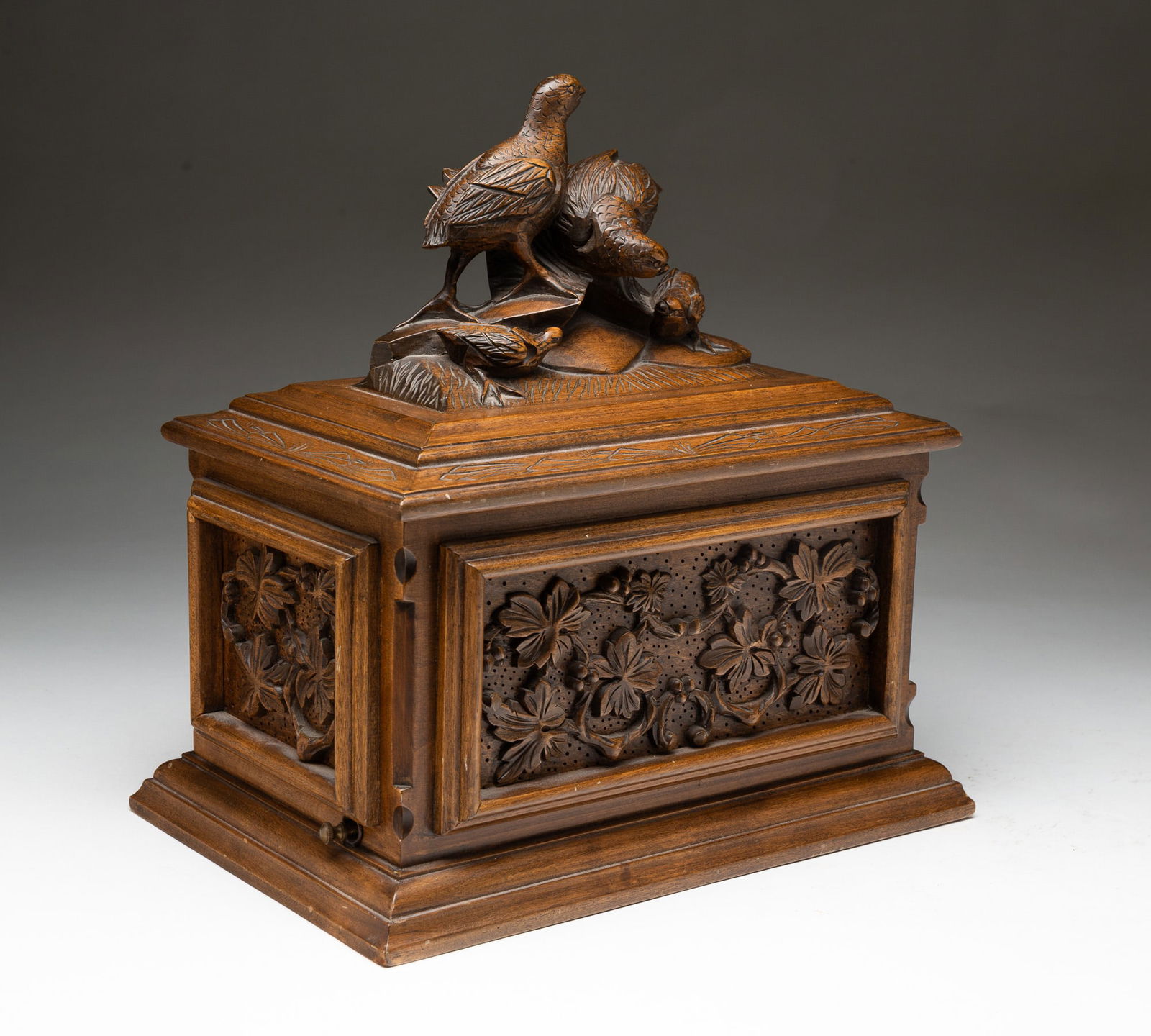THE GAZO FAMILY CLOCK CO. (SAN DIEGO, CALIFORNIA) "CARONA DEL MAR" CARVED WALNUT MUSIC BOX, DATED: The Gazo Family Clock Co. (San Diego, California), dated (19)88. Walnut. Heavily carved foliate and floral panels and well done quail family on lid. Seventy-two note Reuge movement. Serial number 4462