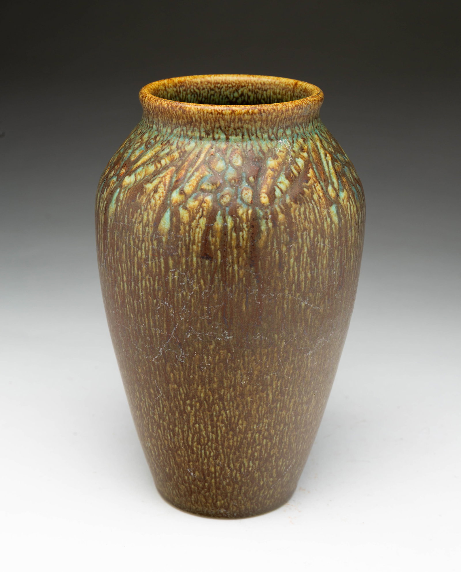 WILLIAM E. HENTSCHEL (1892-1962) FOR ROOKWOOD POTTERY (CINCINNATI, OHIO) OMBROSO VASE, DATED 1915.: William E. Hentschel (American, 1892-1962) for Rookwood, 1915. Of ovoid form with pronounced top rim, having a mottled brown, green and yellow glaze with carved botanical forms at neck and shoulder, w