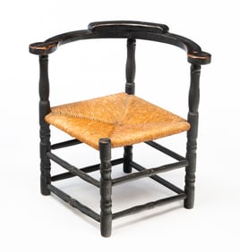 AMERICAN EBONIZED CORNER ARMCHAIR.