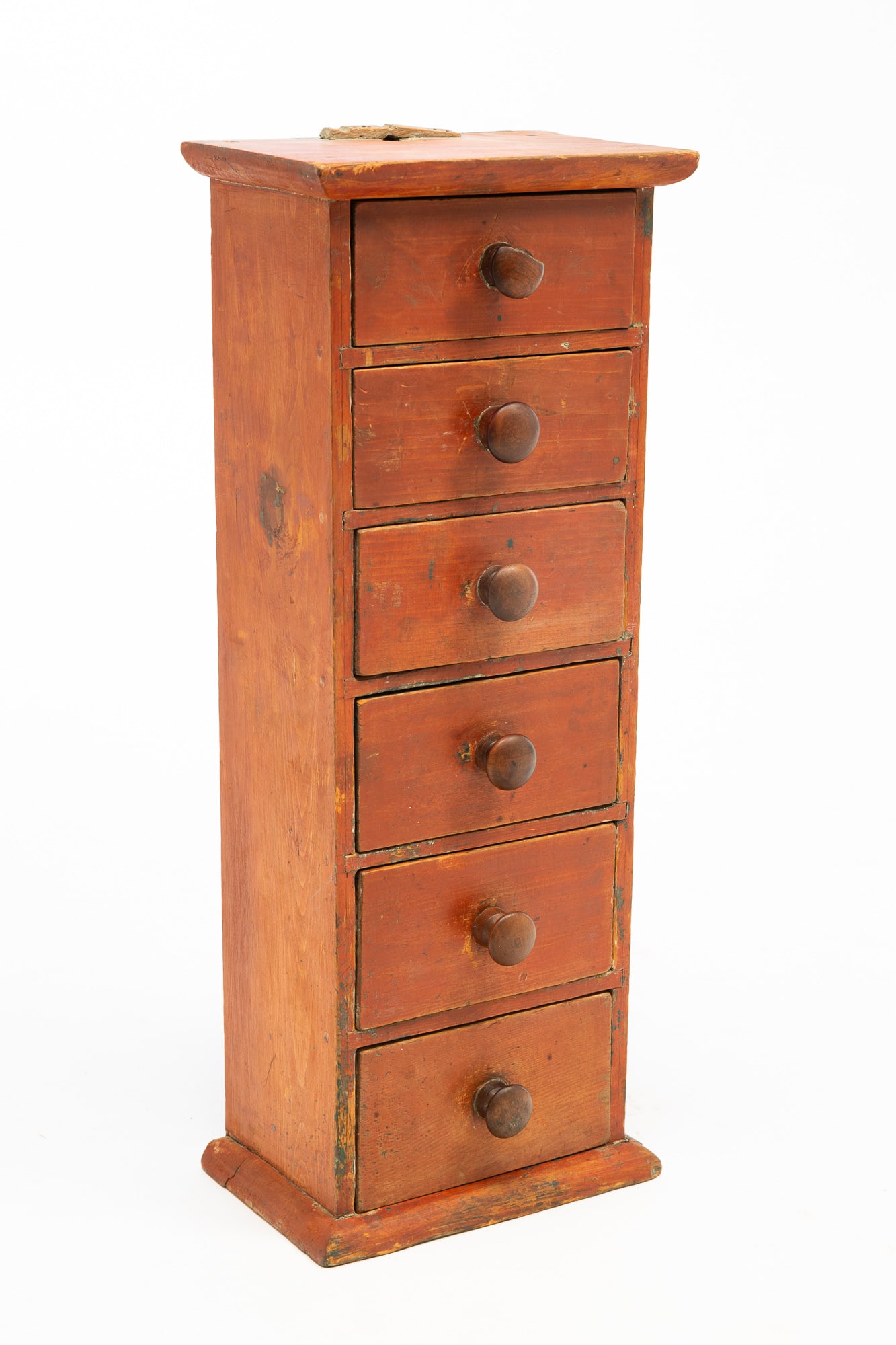 AMERICAN BITTERSWEET-PAINTED PINE HANGING SPICE DRAWERS.: American, Mid-19th Century. Pine. Top and base with rounded edges, six dovetailed drawers and original bittersweet paint. 24.25"h. 9.5"w. 6"d.Provenance: From the Lifetime Collection of the late Joann