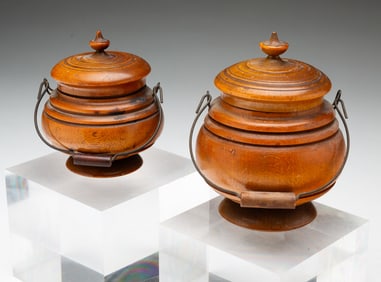 TWO DIMINUTIVE PEASEWARE LIDDED JARS WITH BAIL HANDLES.