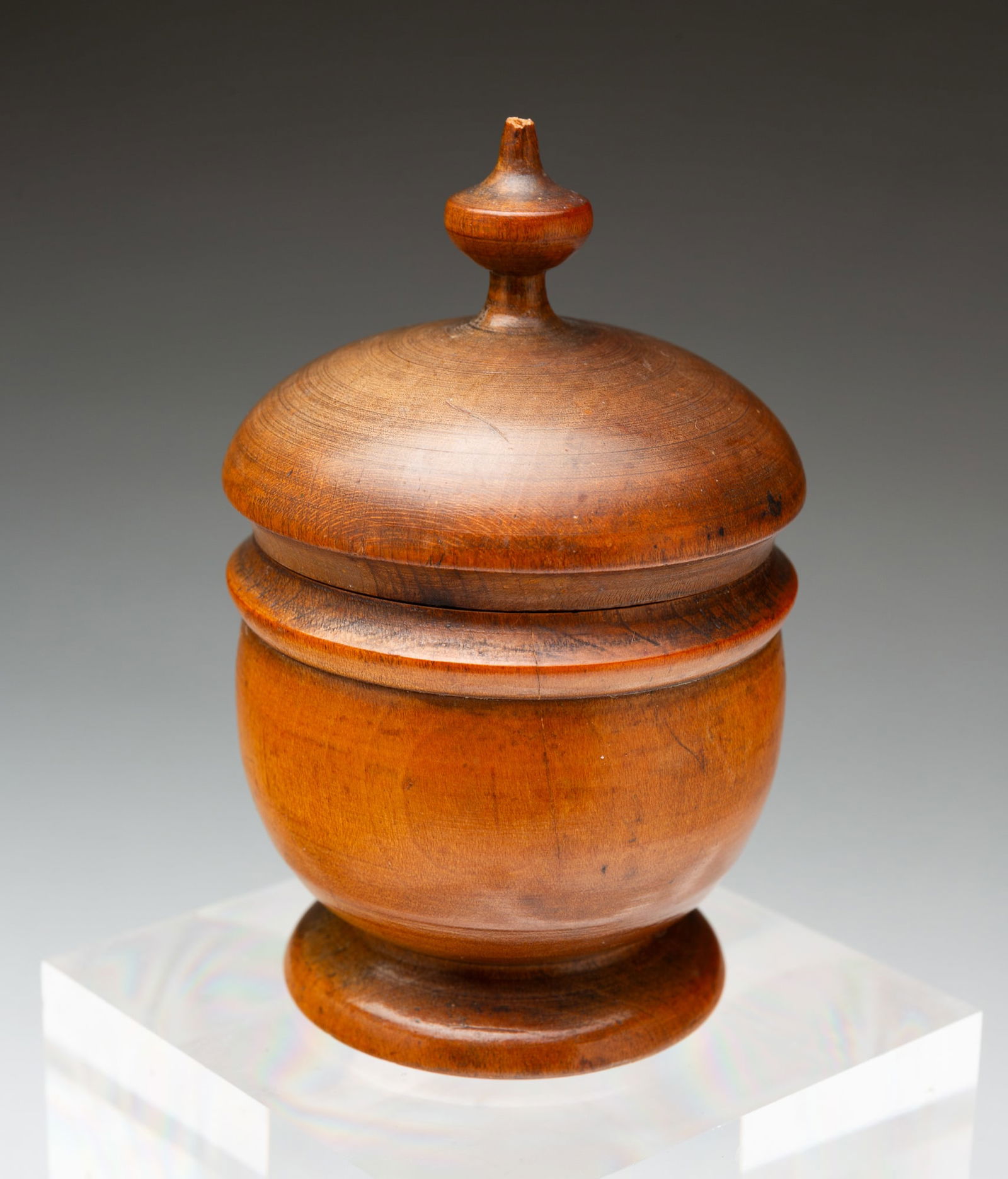 PEASEWARE LIDDED JAR.: American (Ohio), 19th Century. Turned wood jar having a lid with an urn finial and rings, a raised shoulder, a bulbous body, and a flared foot. 4"h. 2.25"d.Provenance: From the Lifetime Collection of
