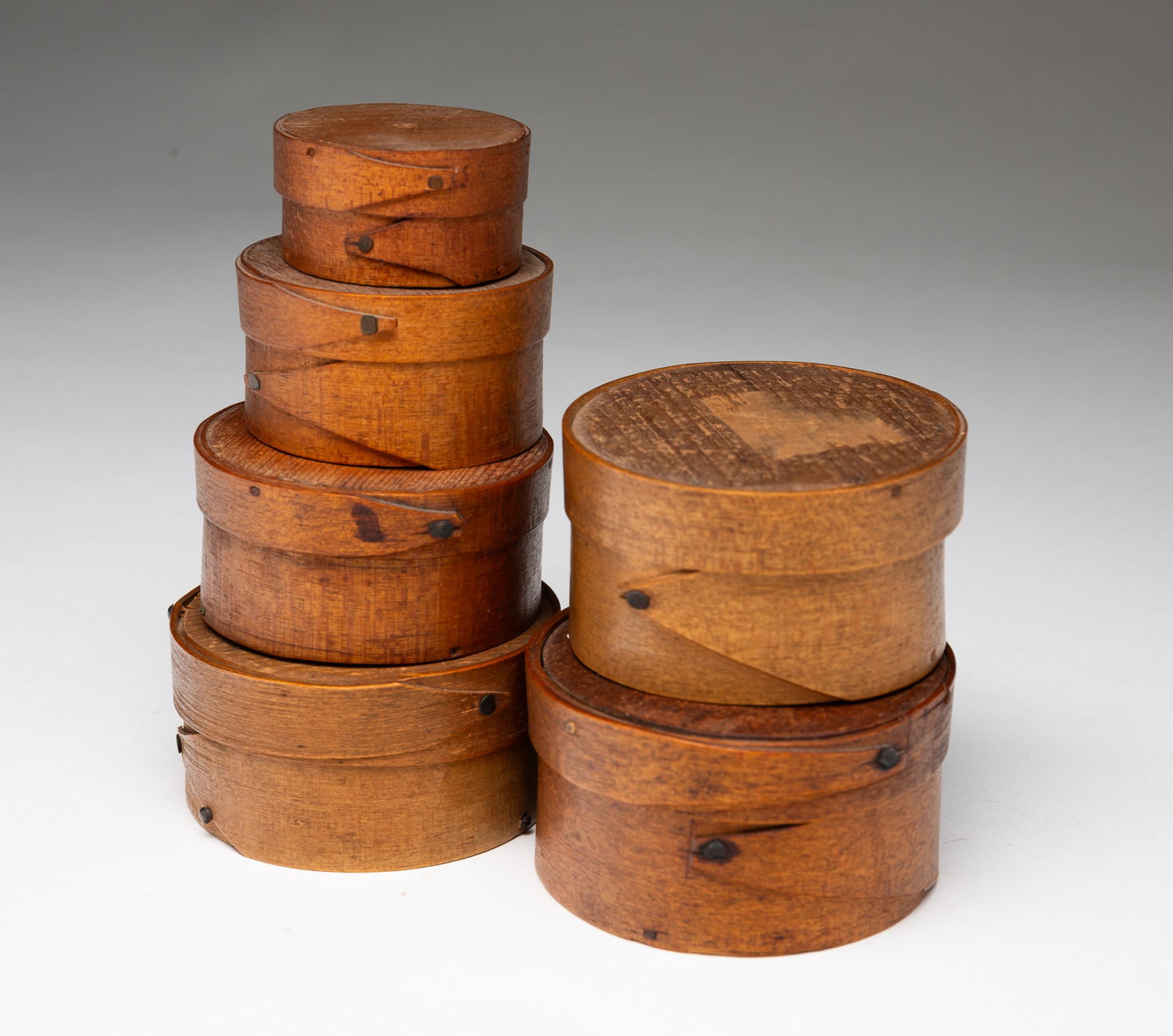 SIX DIMINUTIVE AMERICAN ROUND BENTWOOD BOXES.: American, 19th-20th Century. Six round-lidded boxes with finger joints in graduated sizes. 1.75"d. to 2.75"h.Provenance: From the Lifetime Collection of the late Joanne & David Hill (Arcanum, Ohio); t