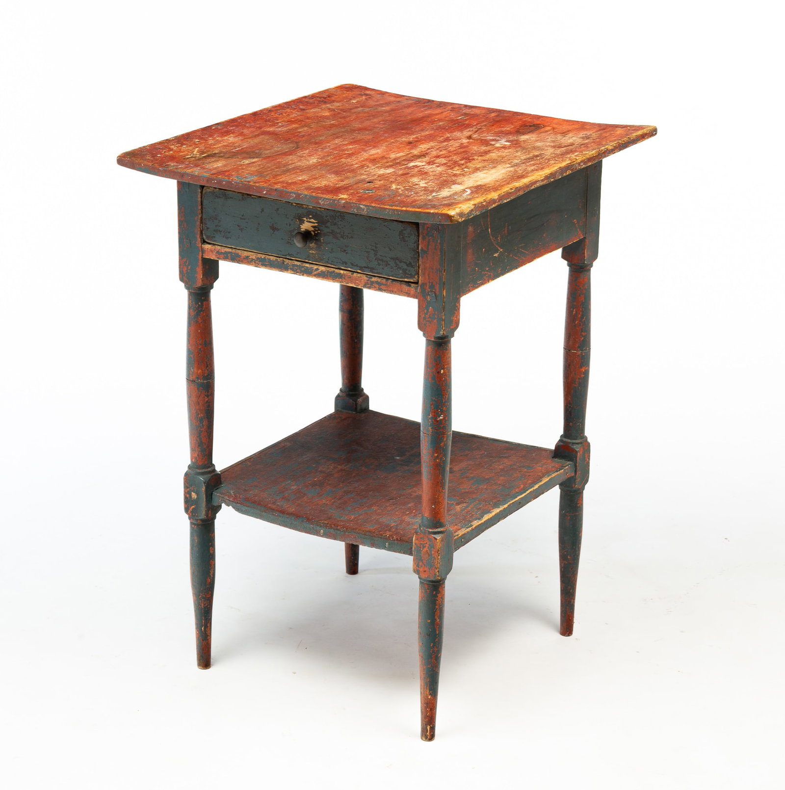 AMERICAN SHERATON PAINTED POPLAR ONE-DRAWER STAND.: America, First half 19th Century. Poplar. Top with generous overhang, dovetailed drawer, lower shelf, turned legs and blue repaint has been partially scraped down to original reddish-brown. 27.75"h. 1