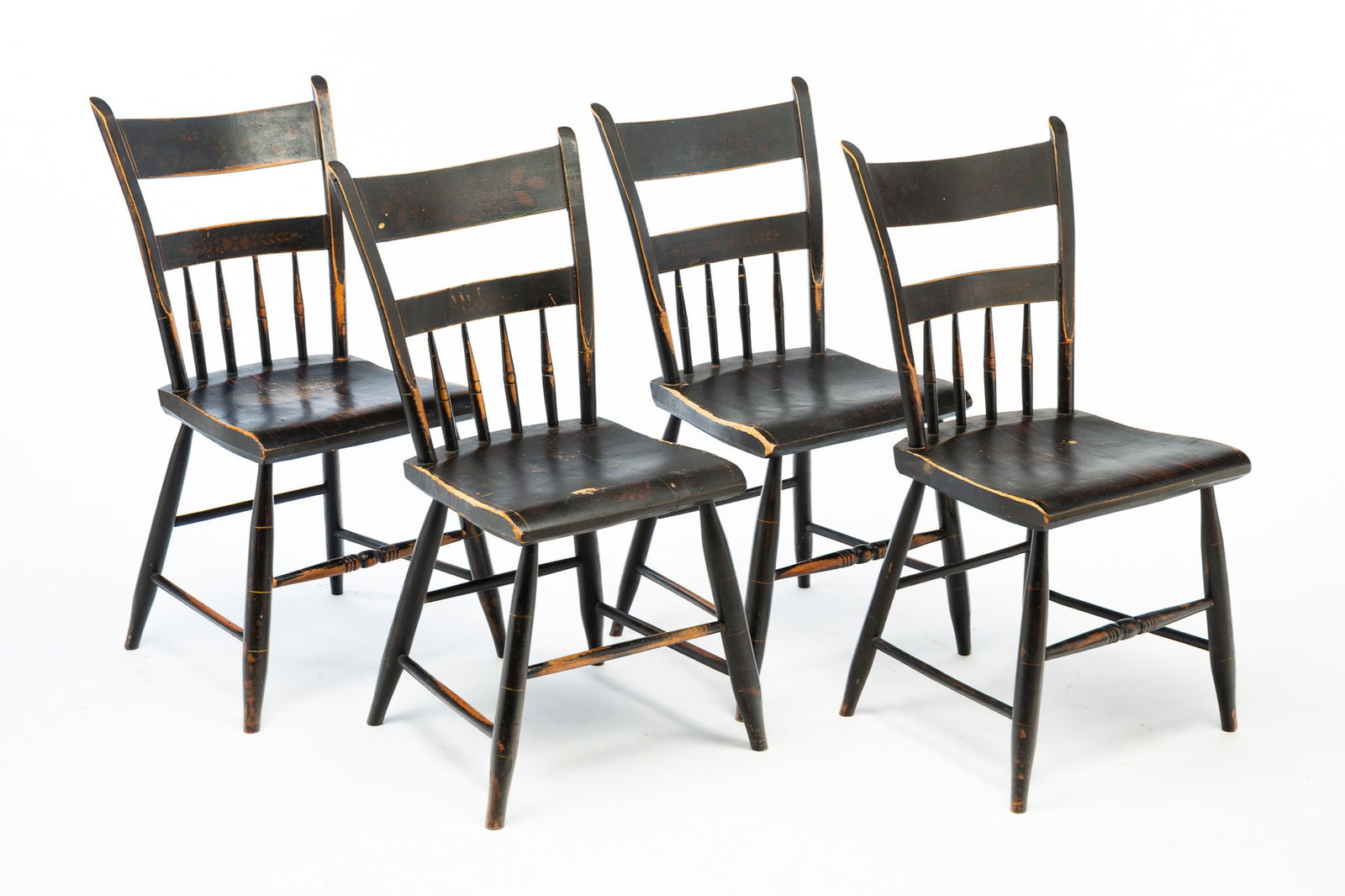 FOUR AMERICAN PAINTED HALF-SPINDLE BACK SIDE CHAIRS.: American, First half 19th Century. Mixed woods. Plank seats, worn original black and red grain paint and bronze color floral and foliate stenciling. 17.75" seat h. 33.75"h.Provenance: From the Lifetim