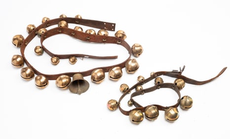 TWO SETS OF GRADUATED BRASS SLEIGH BELLS ON LEATHER STRAPS.