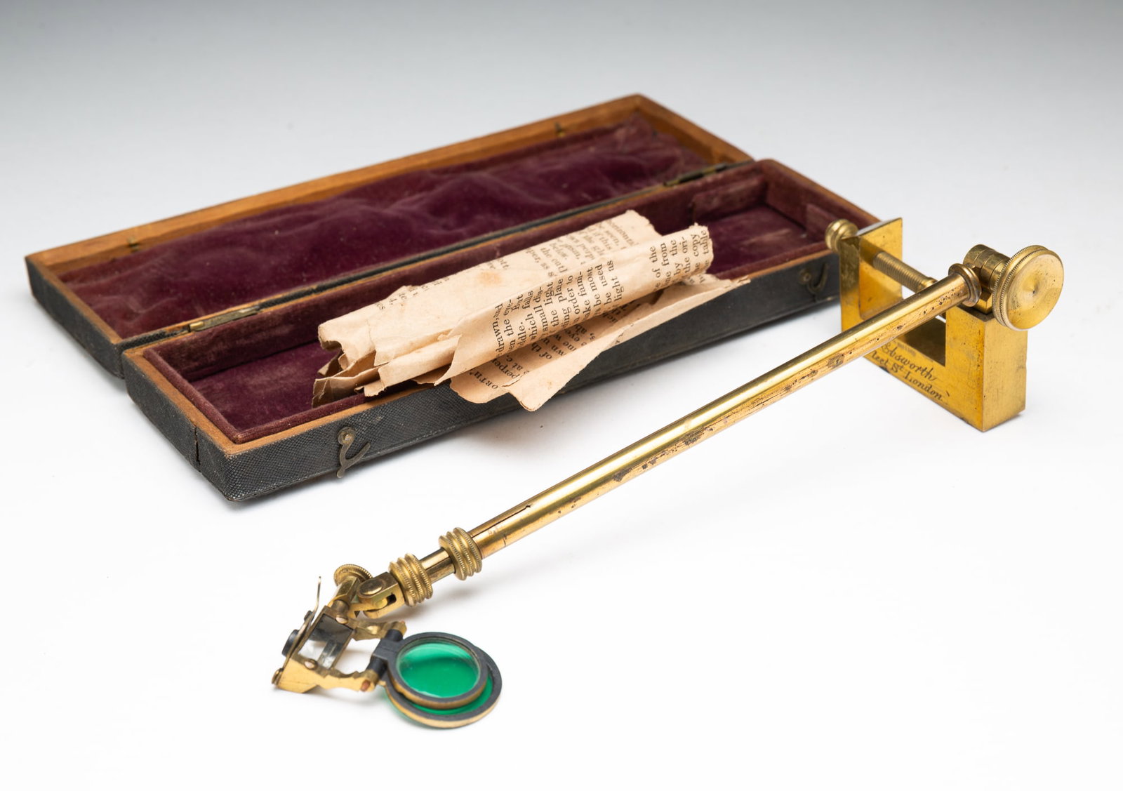 EBSWORTH'S IMPROVED CAMERA LUCIDA BRASS CAMERA LENS.: England (London), ca. 1900. Velvet-lined box containing a brass table clamp and telescoping rod with two lenses, with original paper instructions. Box, 1"h. 9"w. 2.75"d.Provenance: From the Lifetime C