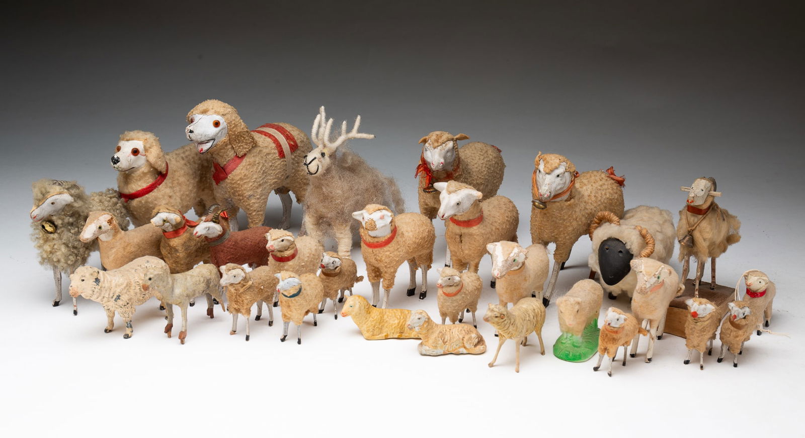 COLLECTION OF THIRTY-ONE GERMAN PUTZ SHEEP, GOAT, AND POODLE FIGURINES.: Germany, ca. 1900. Comprising 18 stick-leg and wooly sheep, four stick-leg and wooly goats, two poodles, a reindeer, and six sheep of various materials, in various sizes. Largest, 5.75"h. 6.25"l.Prove