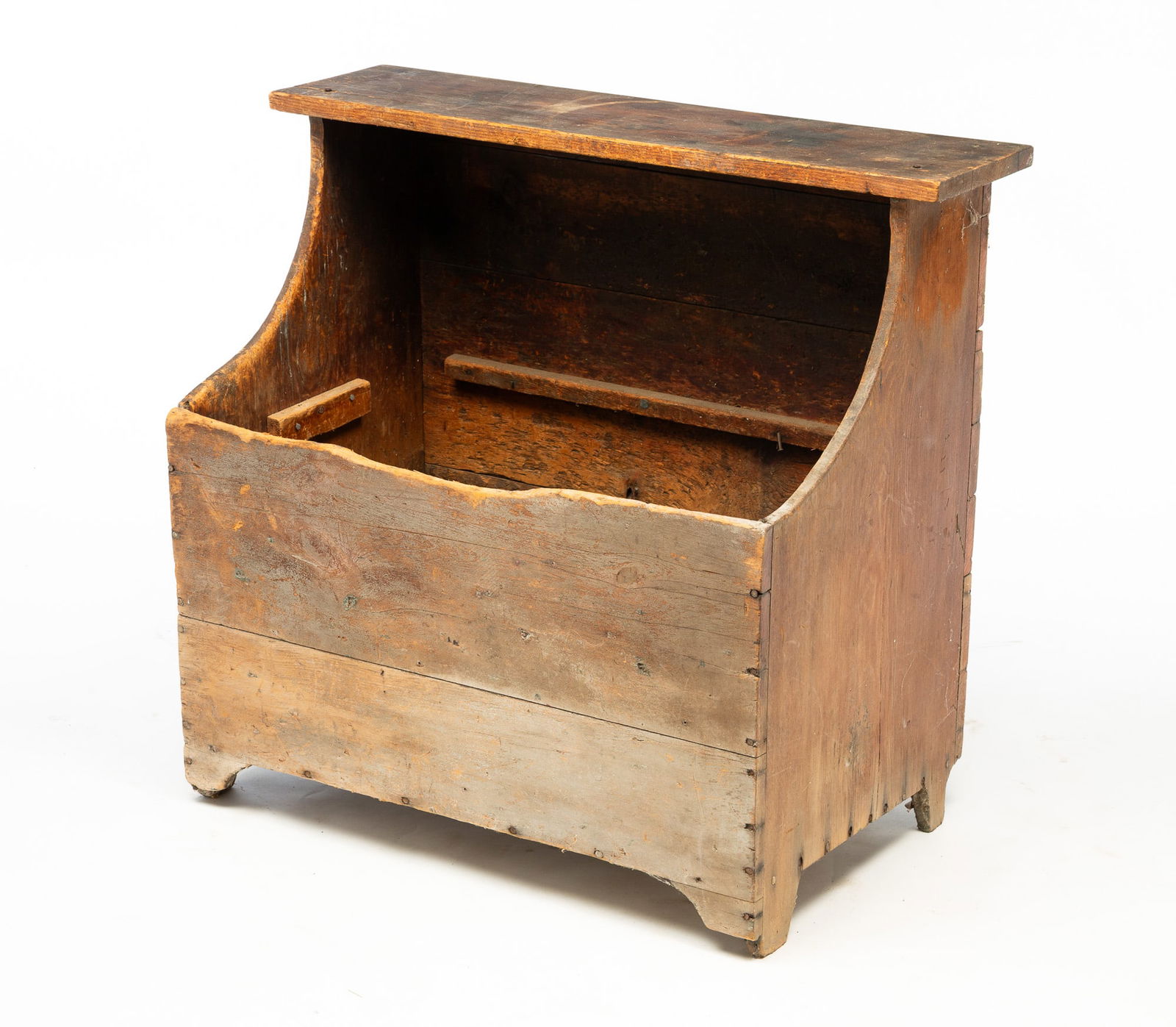 AMERICAN PINE FIREWOOD BIN.: America, Late 19th Century. Pine. One-board top shelf, shaped ends, cut out feet and weathered surface. Round nail construction. 30.75"h. 33.5"w. 18.5"d.Provenance: From the Lifetime Collection of the