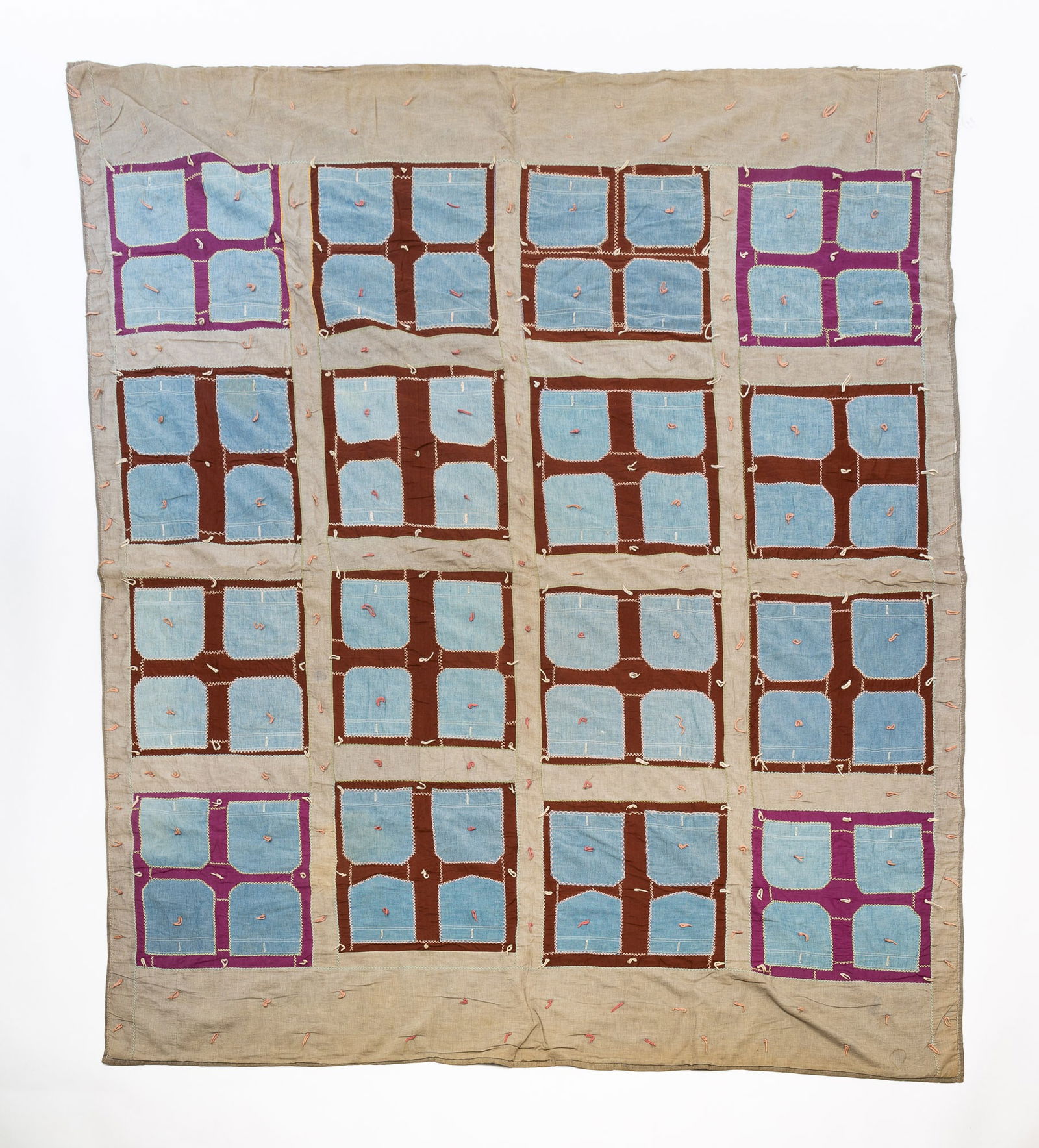 AMISH (MIFFLIN COUNTY, PENNSYLVANIA) TIED AND STITCHED COMFORTER.: Amish (Mifflin County, Pennsylvania), ca. 1900. Cotton and wool. Chambray pocket forms within blue and brown squares within gray chambray borders and having colorful herringbone stitching and ties. 84