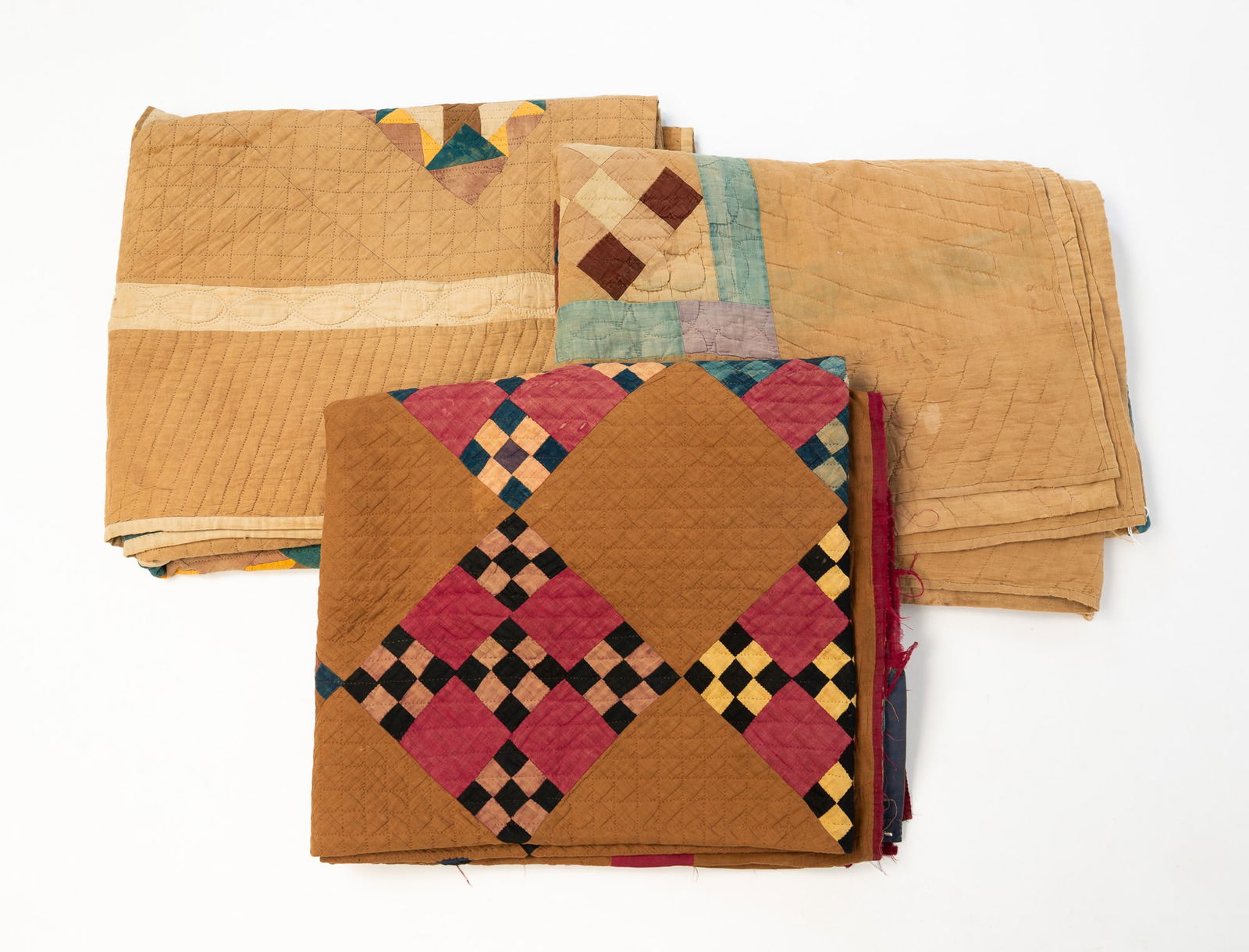 THREE AMISH "NINE PATCH" QUILTS.: Amish (likely Ohio), Late 19th to early 20th Century. The first having polychrome checkered squares on an ochre field within a magenta border. Approx. 75"l. 65"w. The second having polychrome squares