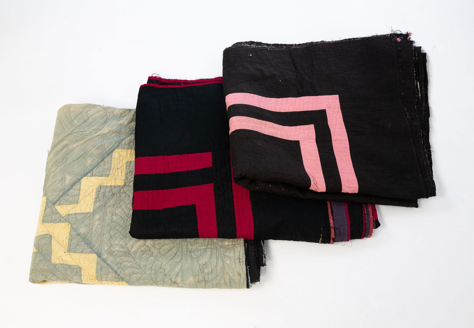 THREE AMISH QUILTS.: Amish (likely Ohio), Late 19th to early 20th Century. Cotton. The first having a light blue field with yellow zigzags. Approx. 82"l. 67"w. The second a "Plain" quilt having a black field with a double