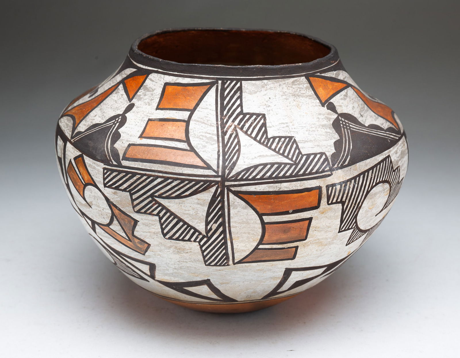 ACOMA PUEBLO POLYCHROME POTTERY OLLA JAR.: Acoma Pueblo (New Mexico), Early 20th Century. Thin-walled pottery vessel decorated in black, white, and orange geometric and botanical designs. 7"h. 8.25"d.Provenance: From the Lifetime Collection of