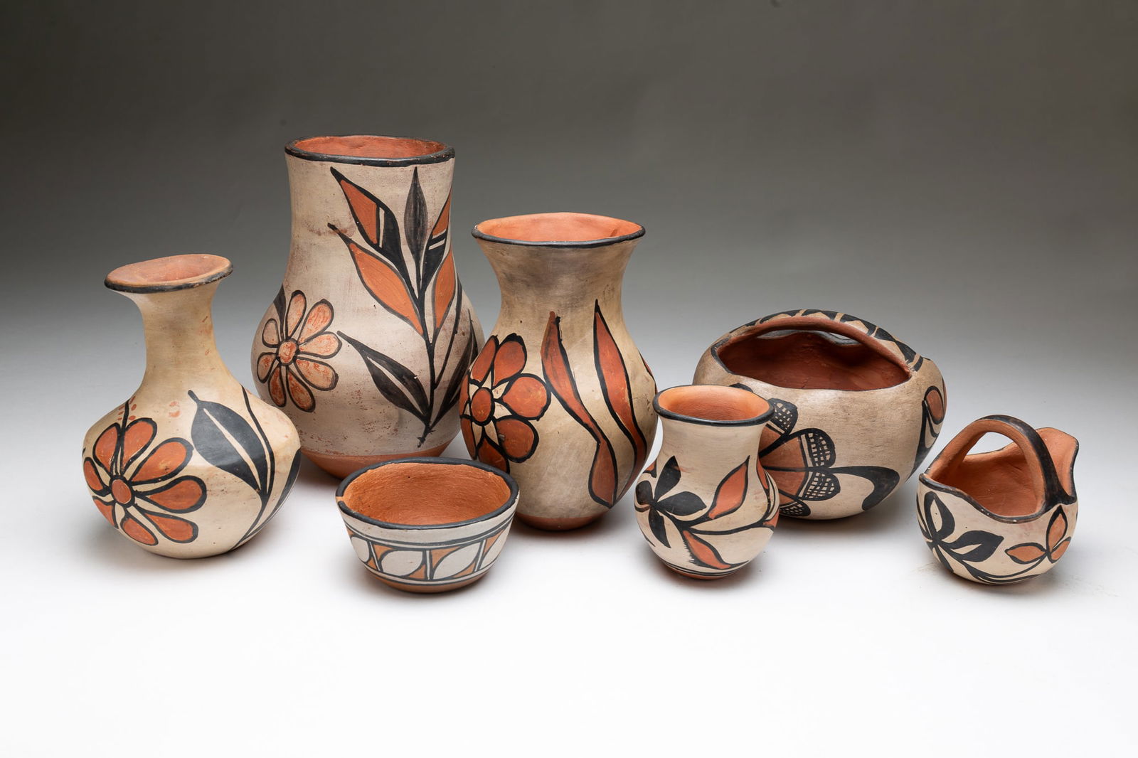 SEVEN SANTO DOMINGO (KEWA) PUEBLO DECORATED POTTERY VESSELS.: Santo Domingo (Kewa) Pueblo (New Mexico), Early 20th Century. Including four vases in various forms, a handled bowl with ruffled rim, 5.25"h., a diminutive bowl, 2"h. 4"d., and a handled double spoute