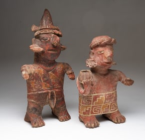 TWO NAYARIT POLYCHROME DECORATED STANDING TERRACOTTA FIGURES OF A WARRIOR AND A FEMALE.