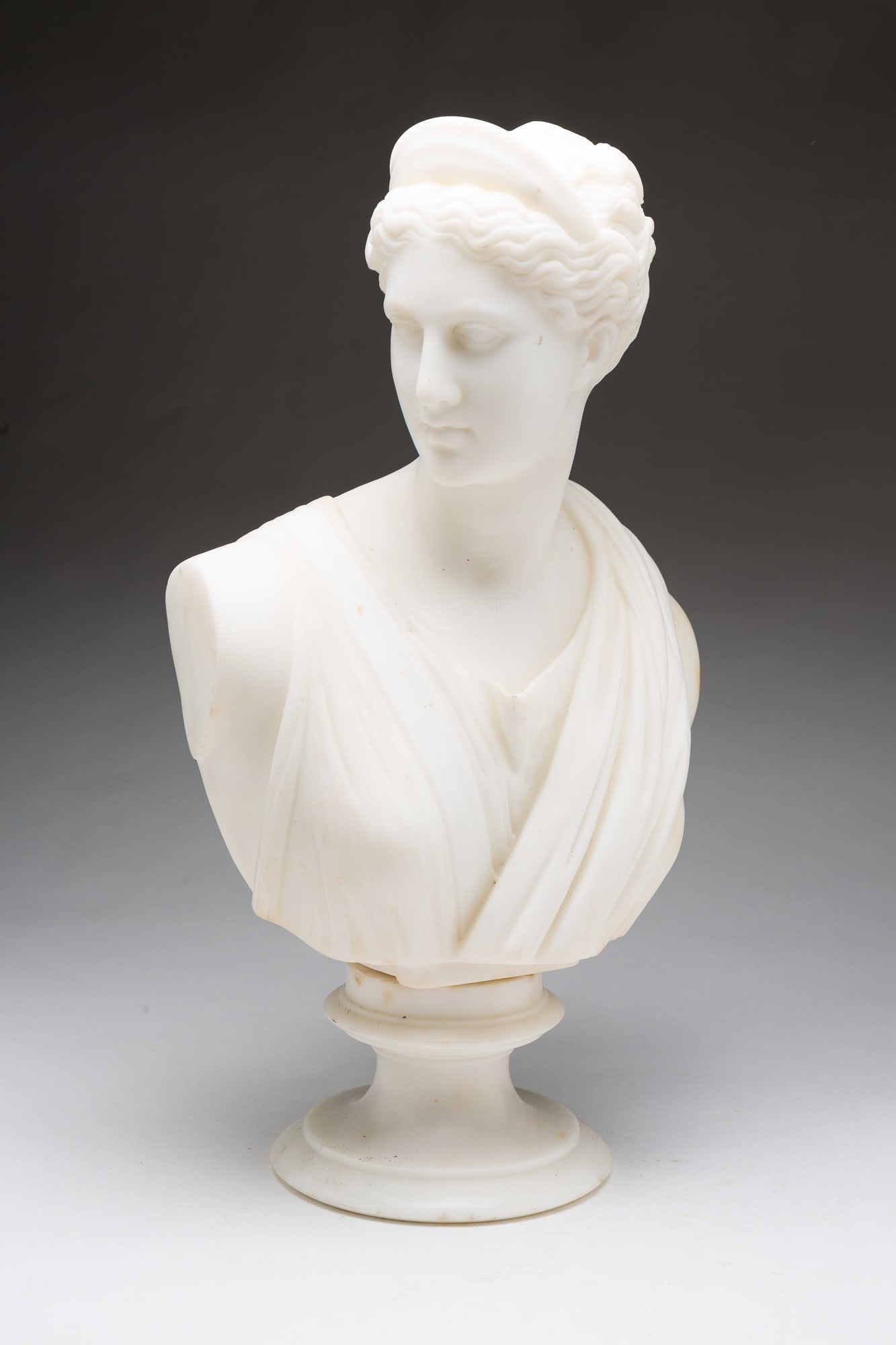 C. SCHEGGI AND BROTHERS (ITALIAN, 19TH CENTURY) ALABASTER BUST OF THE GODDESS DIANA.: Italy (Florence), 19th Century. Alabaster. Bust of a goddess looking to her right, wearing a tiara on her head with her hair tied back and robes, on a circular socle, signed "C. Scheggi e Flli Firenze