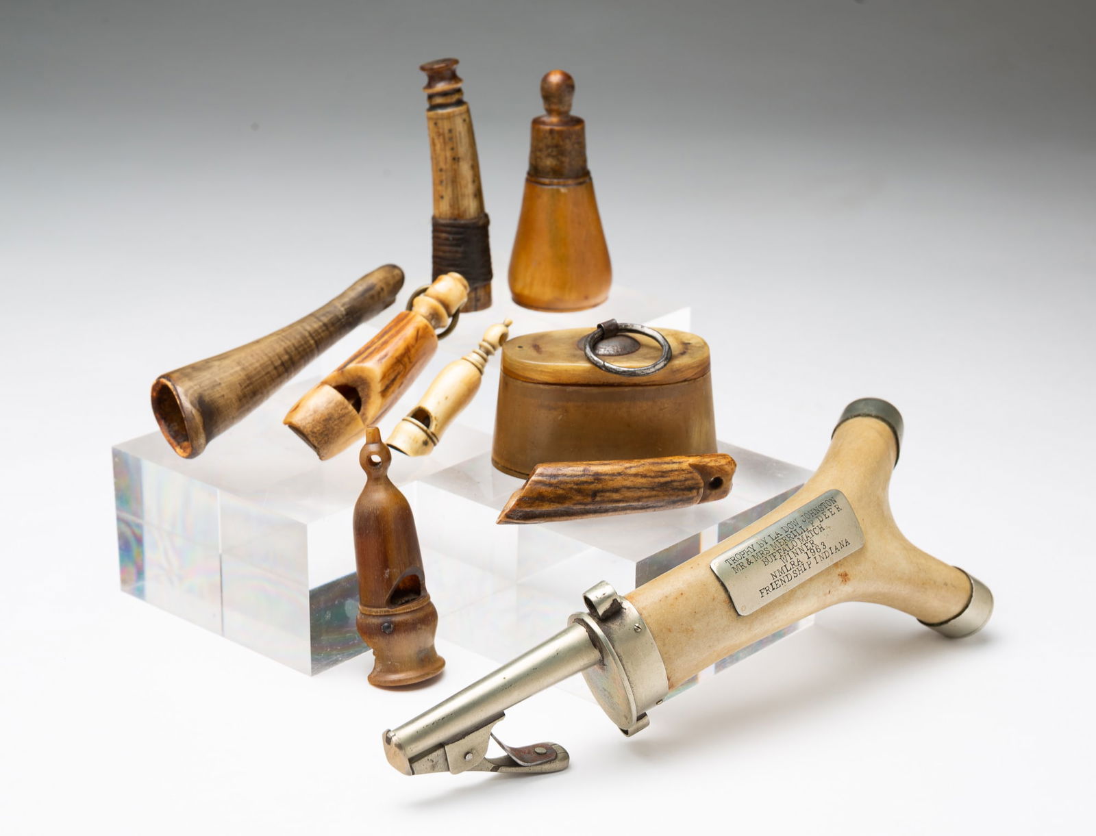 ANTLER SHOT FLASK TROPHY PLUS CARVED ANTLER, HORN, AND BONE ITEMS.: American and possibly English, 19th-20th Century. Antler, metal, horn, bone, and natural materials. The antler shot flask trophy has engraved presentation plaque reading "TROPHY BY LA DOW JOHNSTON / M