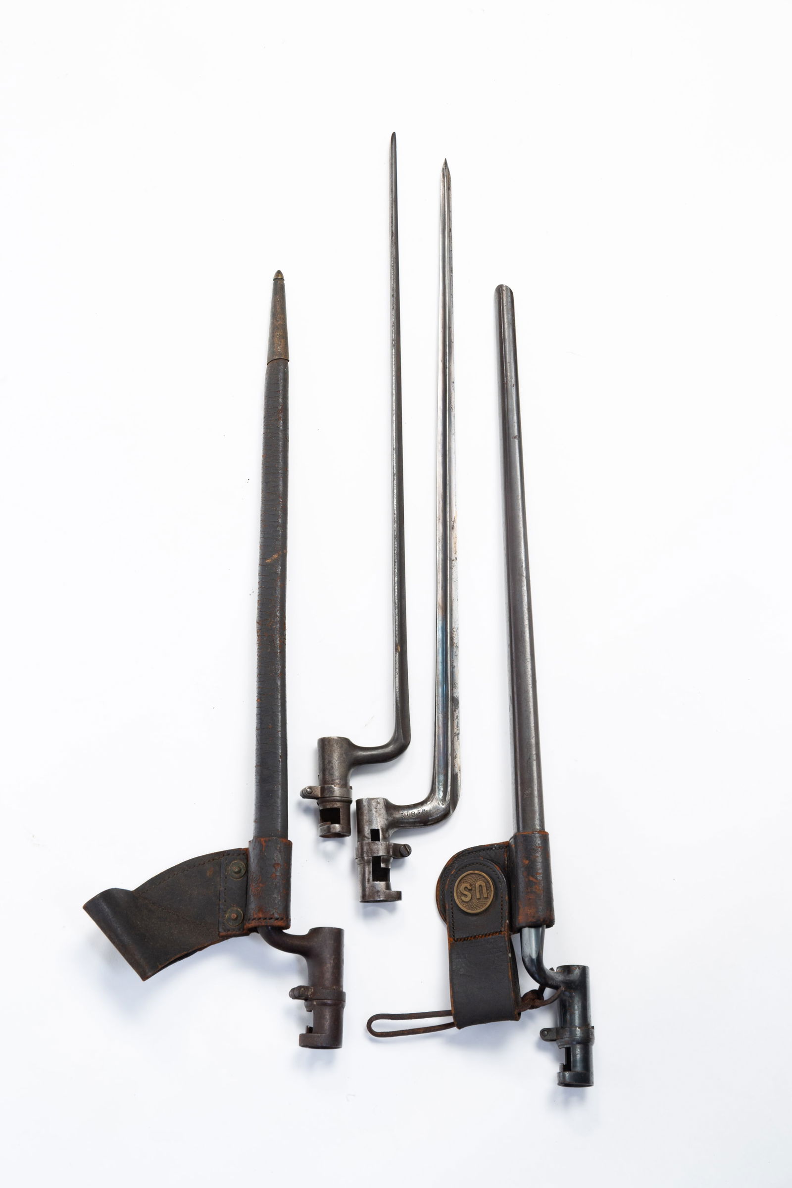 FOUR AMERICAN CIVIL WAR ERA BAYONETS.: American, 19th Century. Three are stamped U.S. and two of the three have scabbards with leather straps. One with brass U.S. medallion. 22"l. 21.5"l. and 20.5"l. Together with the fourth which may be E