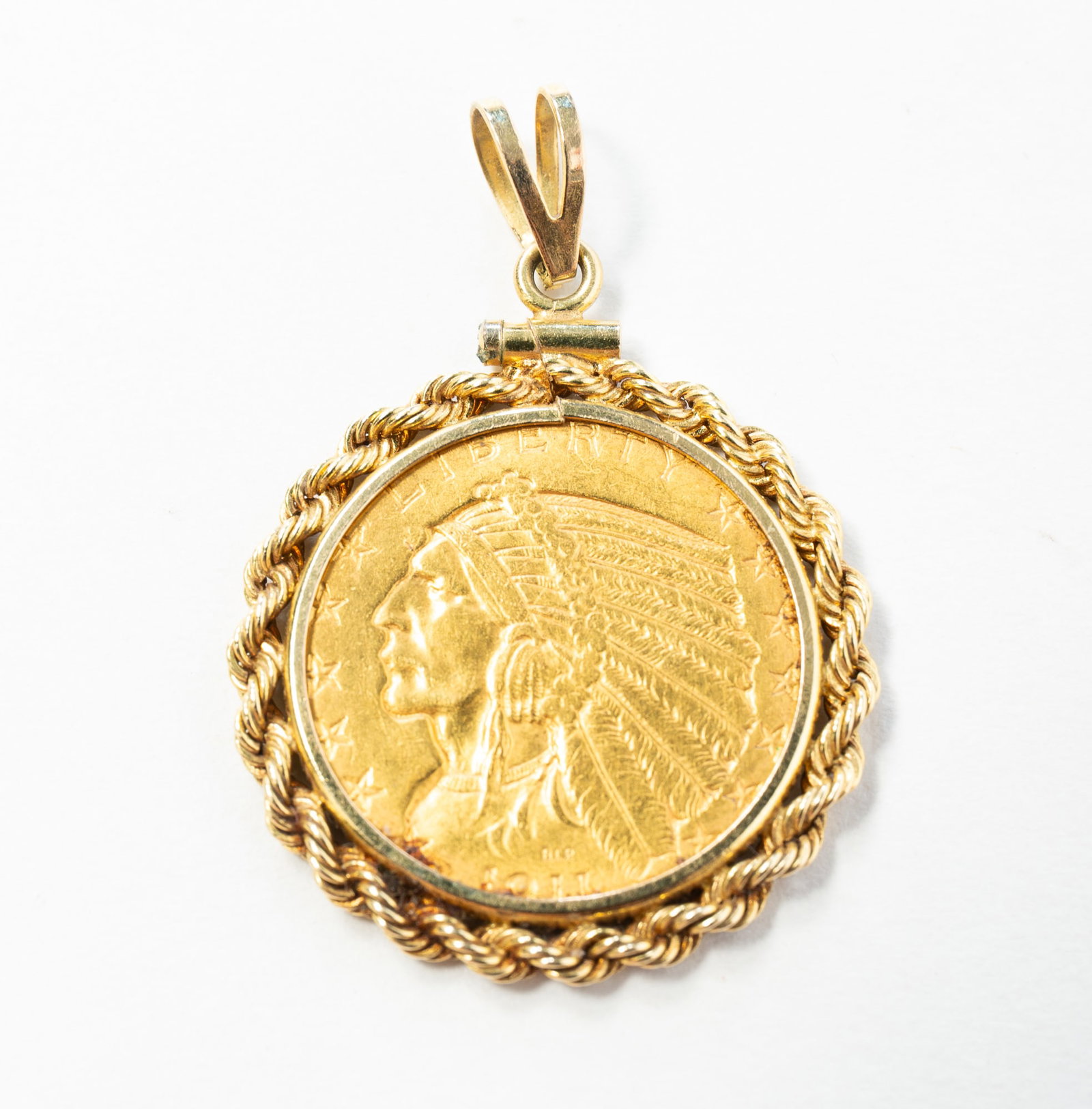 14K YELLOW GOLD BEZEL SET 1911 INDIAN HEAD $5 GOLD COIN.: American, dated 1911. Rope twist bezel holding a $5 Indian head gold coin. Approximately 11.3g.