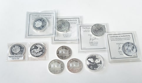 TEN FOREIGN ONE OUNCE FINE SILVER COINS.