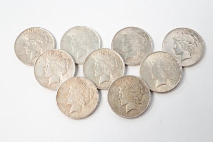 NINE SILVER PEACE DOLLARS.