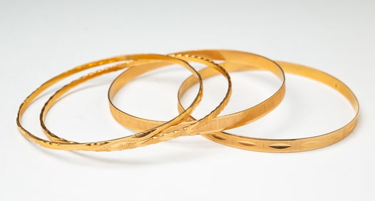 FOUR 18K YELLOW GOLD BANGLES.