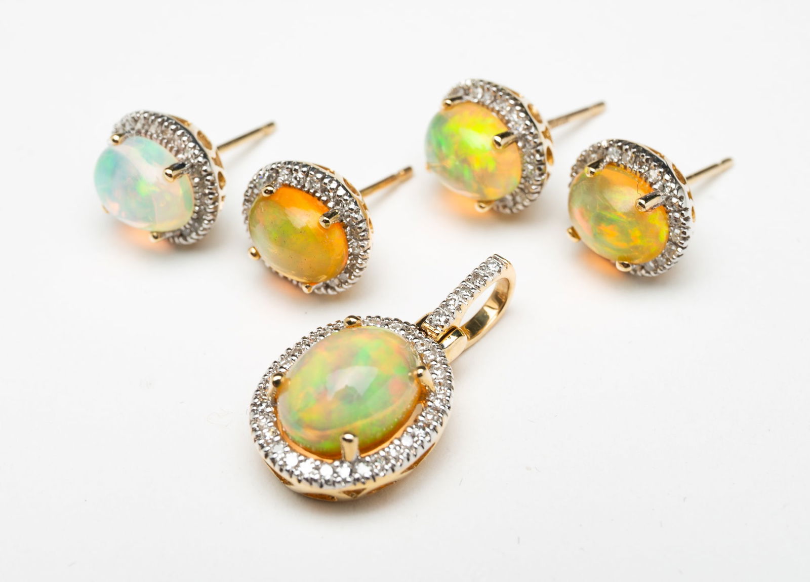 14K YELLOW GOLD OPAL AND DIAMOND EARRINGS AND PENDANT.: Contemporary. 14k yellow gold. Pendant and four semi-matching post back earrings with central opals and surrounded by natural single cut diamonds. Approximately 6.4g.