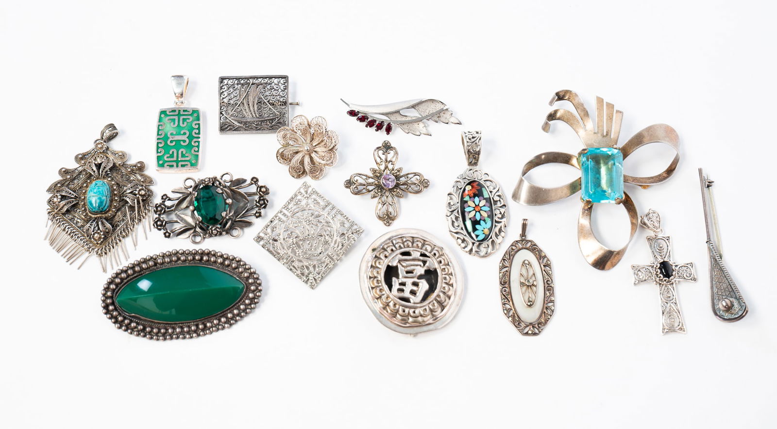 GROUP OF STERLING SILVER PENDANTS AND BROOCHES.: 20th Century. Six gemstone pendants including a Carolyn Pollack onyx inlaid gemstone pendant, an Egyptian Revival filigree pendant set with a turquoise scarab, and a German marcasite and mother of pea