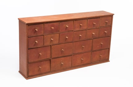 AMERICAN OR ENGLISH MAHOGANY AND PINE RED-PAINTED TWENTY-DRAWER APOTHECARY CABINET WITH LABELS.