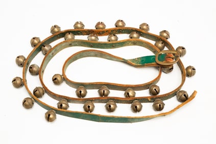 GREEN LEATHER STRAP WITH THIRTY-THREE BRASS SLEIGH BELLS.
