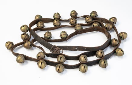LEATHER STRAP WITH THIRTY BRASS SLEIGH BELLS.