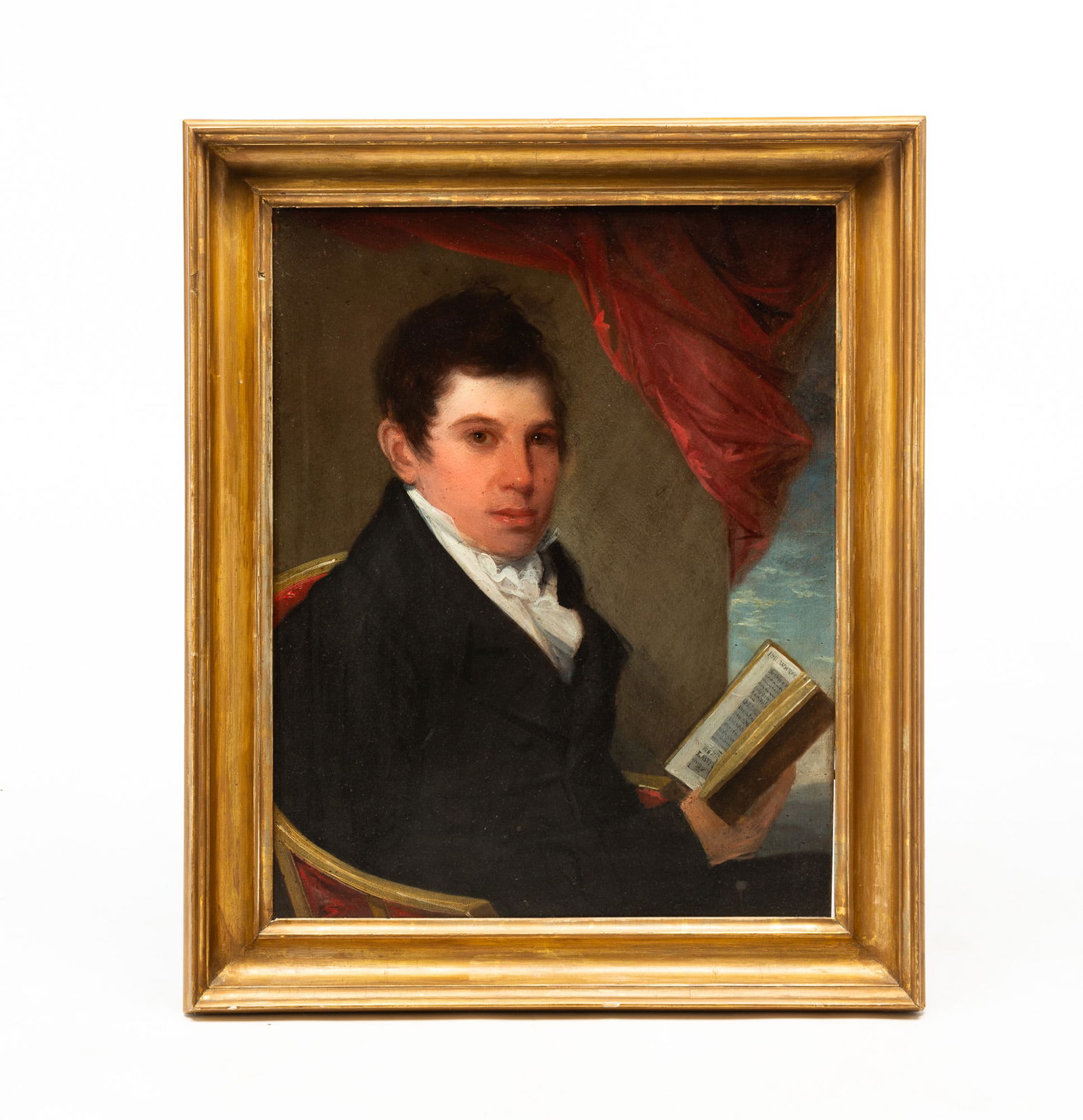 SCHOOL OF GILBERT STUART (AMERICAN, 1755-1828) OIL ON PANEL PORTRAIT OF JONATHAN BASS HOLDING A: Boston, Massachusetts, Early 19th Century. Depicting a young man seated in a chair with hair swept forward and wearing a white shirt, a white tie, and a black coat, holding a book dated 1811, having r
