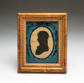 AMERICAN SCHOOL HOLLOW-CUT SILHOUETTE OF A YOUNG MAN UNDER AN EGLOMISE MAT.