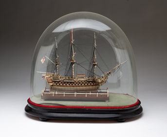 FINELY CARVED AND PAINTED MODEL OF A PRISONER OF WAR SHIP IN A GLASS DOME CASE.