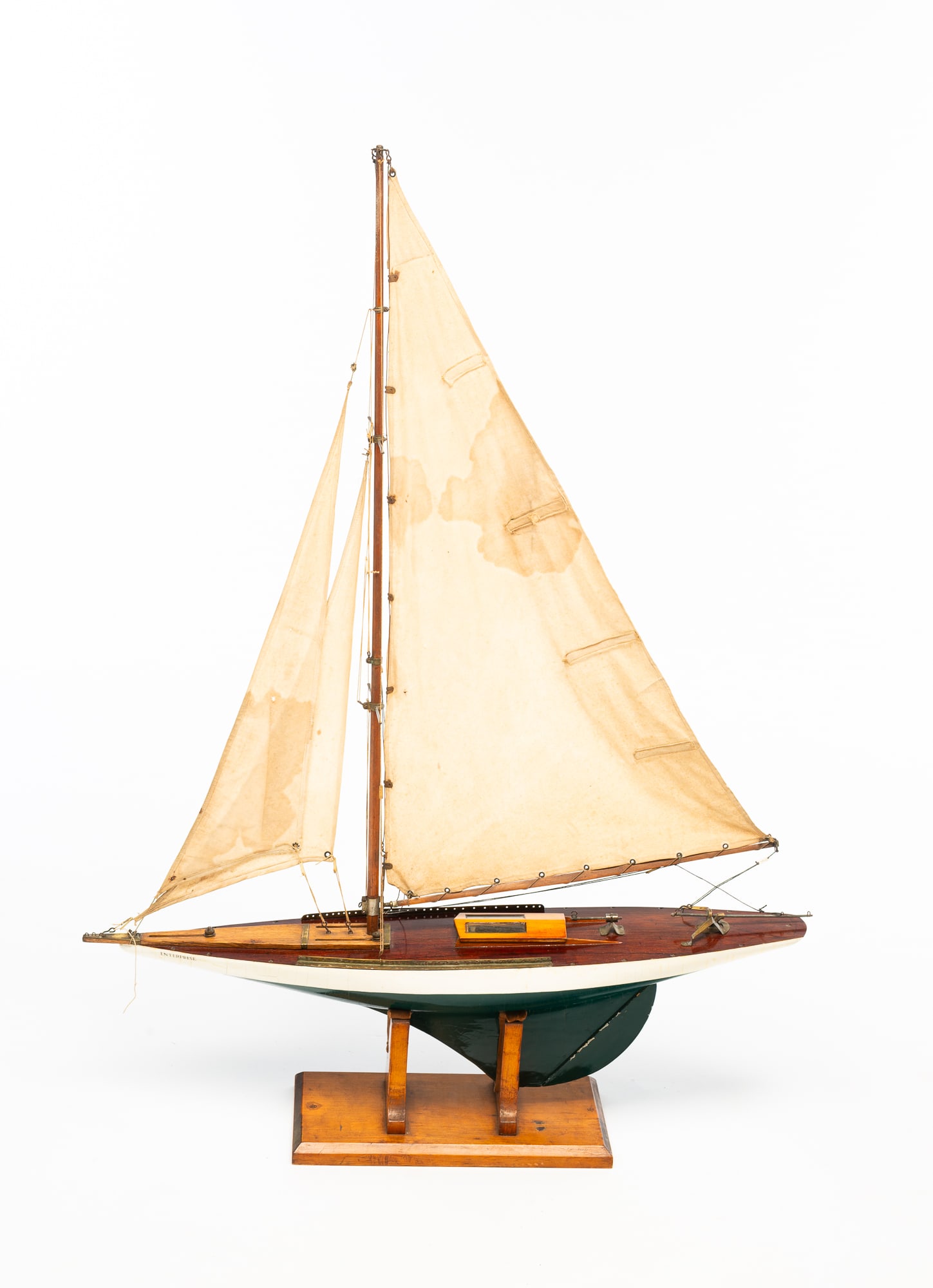 AMERICAN WOOD POND SAILER MODEL BOAT.: Early 20th Century. Scale model of wooden sail boat, Enterprise. Having three stitched linen sails and on a wooden stand. With stand, 43"h. 32.5"w.