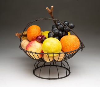 GROUP OF STONE FRUIT IN WIREWORK BASKET.