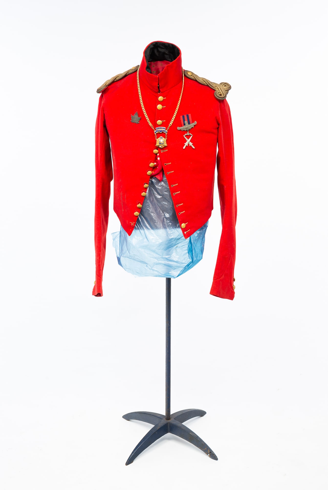 CANADIAN MILITARY RED COAT.: 1840s-1860s. Canadian government hand-sewn red coat with brass buttons and original gold epaulettes; adorned with various medals. Coat, 12.5"h. 15"w.Provenance: From the Lifetime Collection of the lat